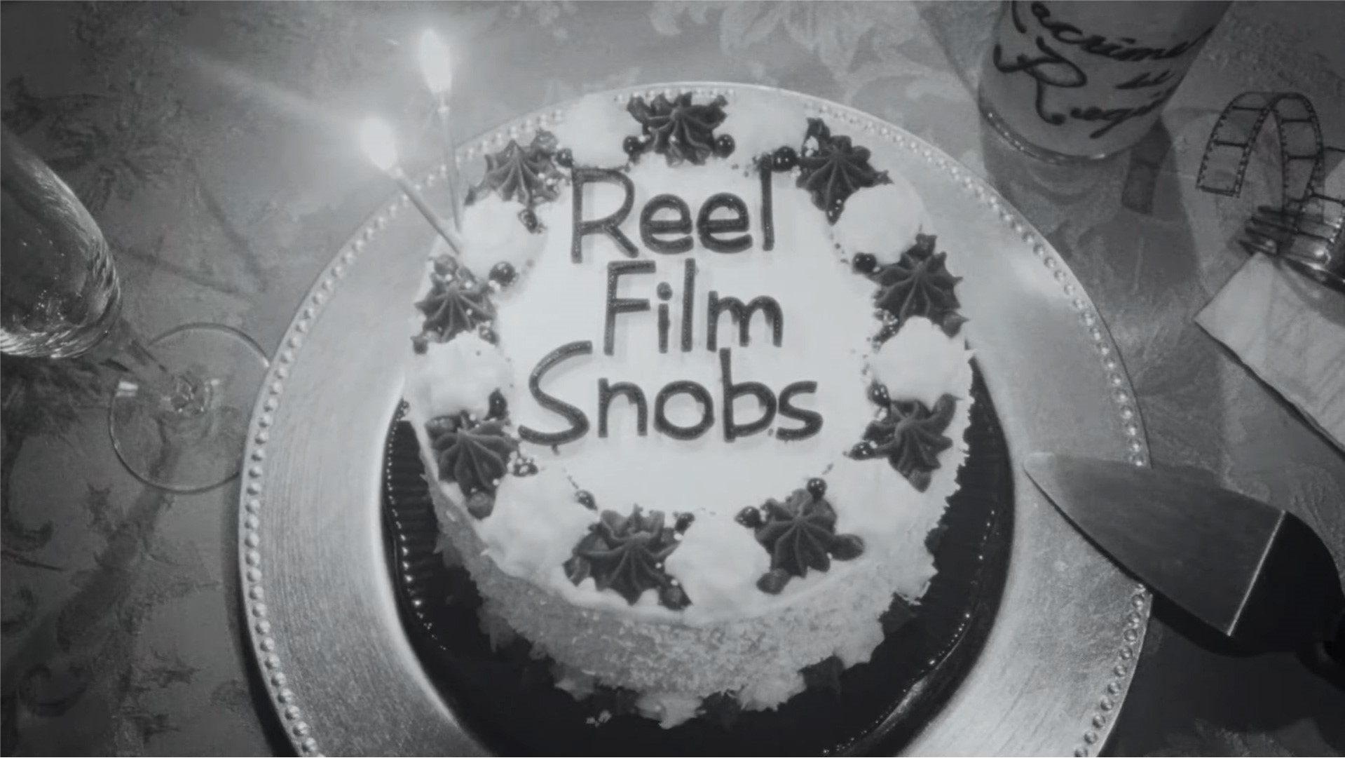 A birthday cake that has Reel Film Snobs spelled out in the frosting.